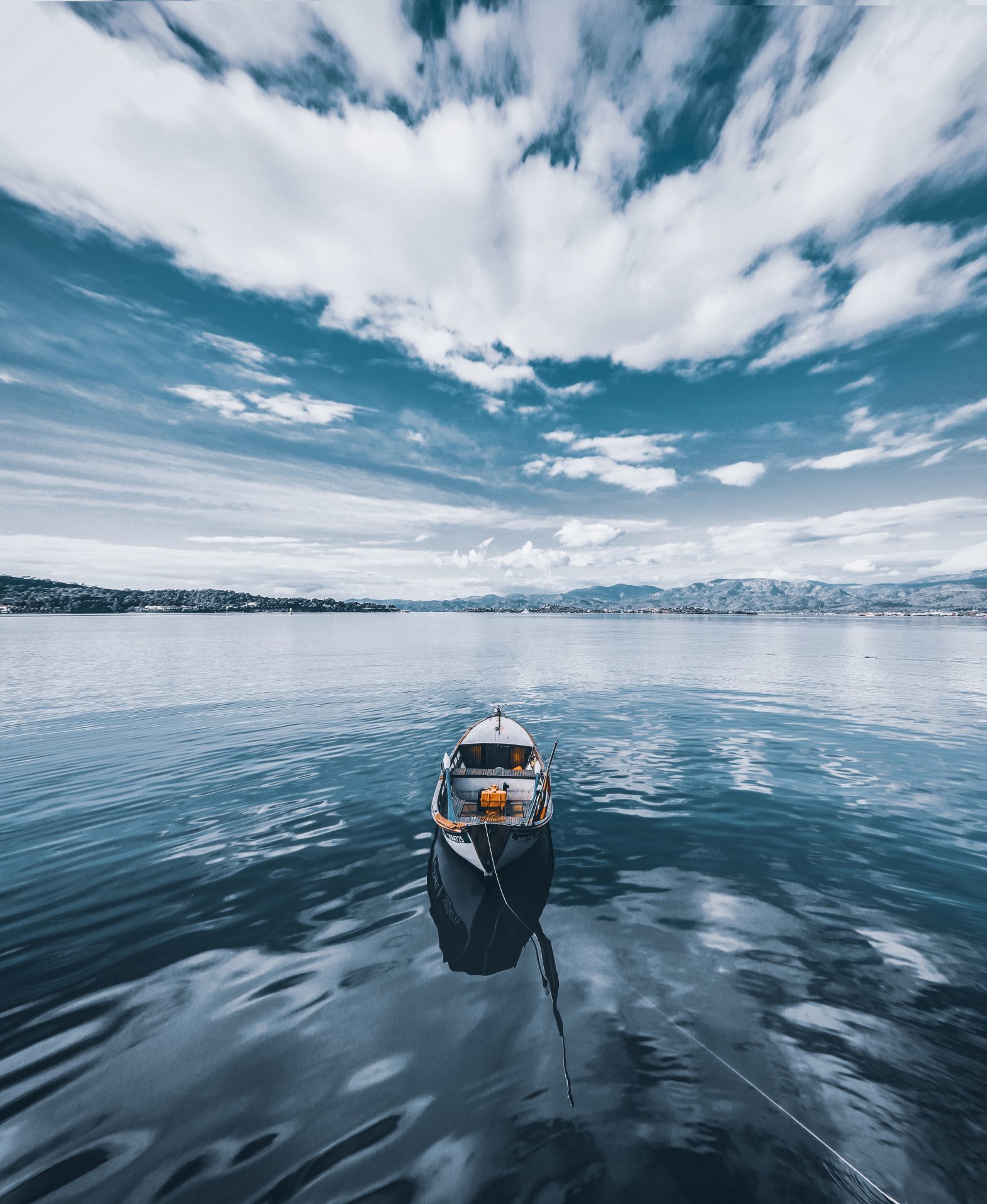 boat on water that is reflecting clouds